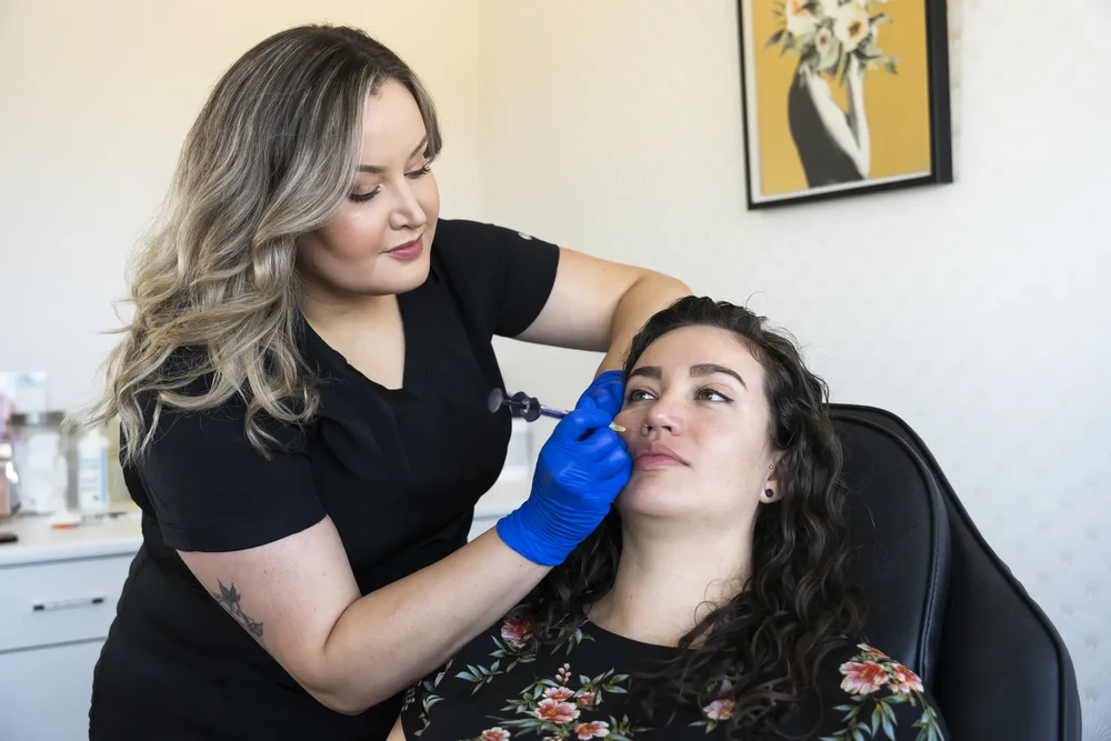A client receives a deoxycholic acid injection from an expert at a Belleville clinic to contour her jawline and reduce chin fat.