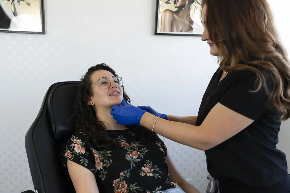 Woman in Belleville smiling after a successful deoxycholic acid treatment, showcasing the results of her fat-dissolving injections.
